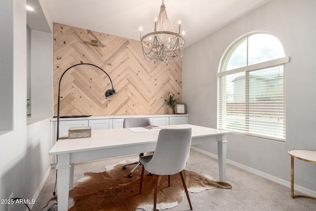 office area with an accent wall, baseboards, wood walls, and a chandelier