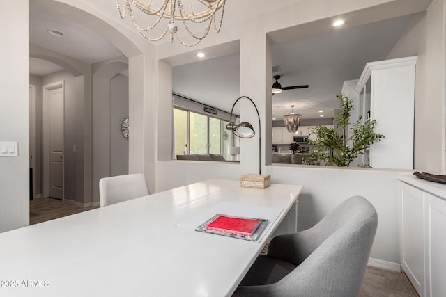 dining area featuring arched walkways, recessed lighting, and ceiling fan with notable chandelier