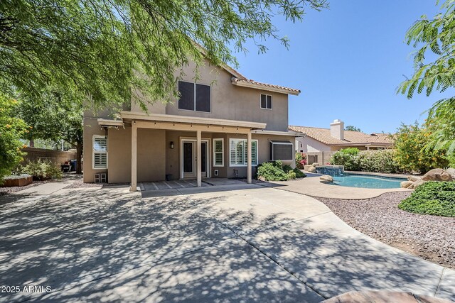 1311 N Congress Dr, Chandler, AZ 85226 - rear view of house featuring stucco siding, a patio, fence, and a pool with connected hot tub