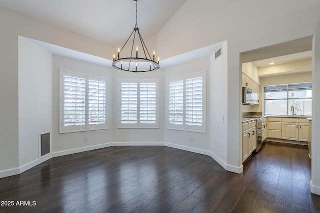 1311 N Congress Dr, Chandler, AZ 85226 - unfurnished dining area with a chandelier, dark wood-style floors, baseboards, a sink, and vaulted ceiling