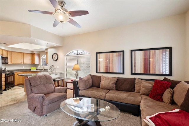 living room featuring a ceiling fan and light colored carpet