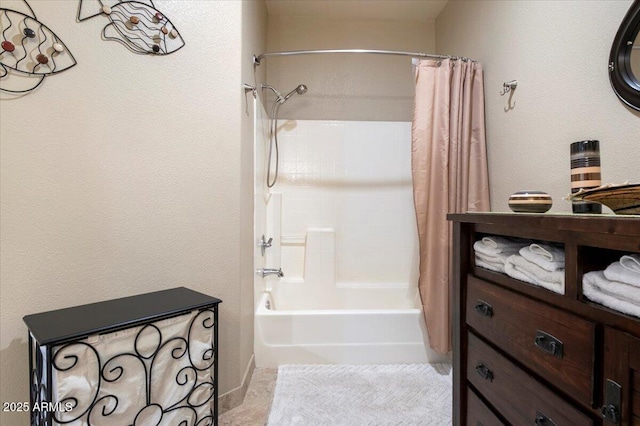 full bath featuring shower / tub combo with curtain and a textured wall