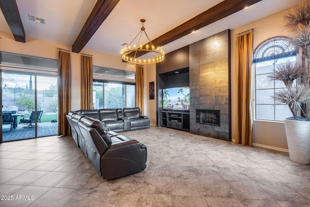 living room with beam ceiling, a notable chandelier, and a fireplace