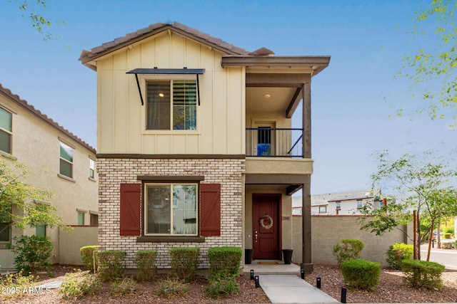 2540 N Stone Hill Rd, Buckeye, AZ 85396 - view of front facade featuring brick siding, board and batten siding, fence, and a balcony