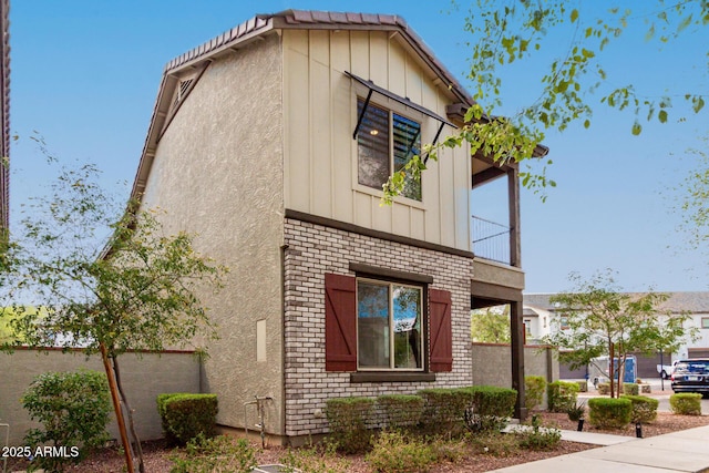 2540 N Stone Hill Rd, Buckeye, AZ 85396 - view of side of property with board and batten siding, brick siding, fence, and a balcony