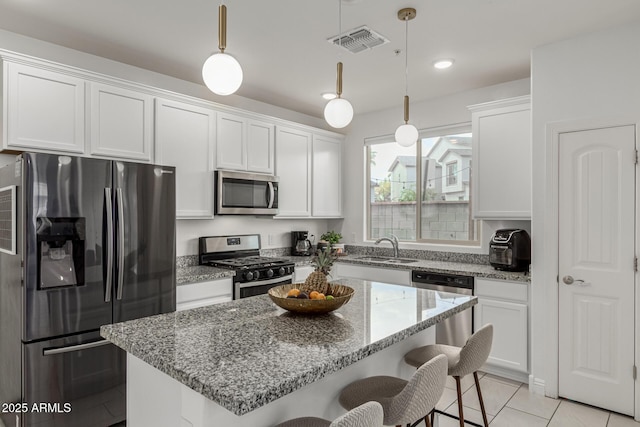 2540 N Stone Hill Rd, Buckeye, AZ 85396 - kitchen featuring visible vents, appliances with stainless steel finishes, white cabinets, and a kitchen bar