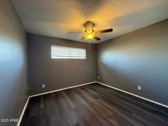 empty room with ceiling fan, a textured ceiling, baseboards, and dark wood-style flooring