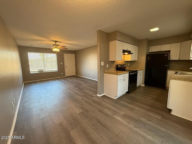 kitchen featuring electric range, white cabinets, open floor plan, freestanding refrigerator, and under cabinet range hood