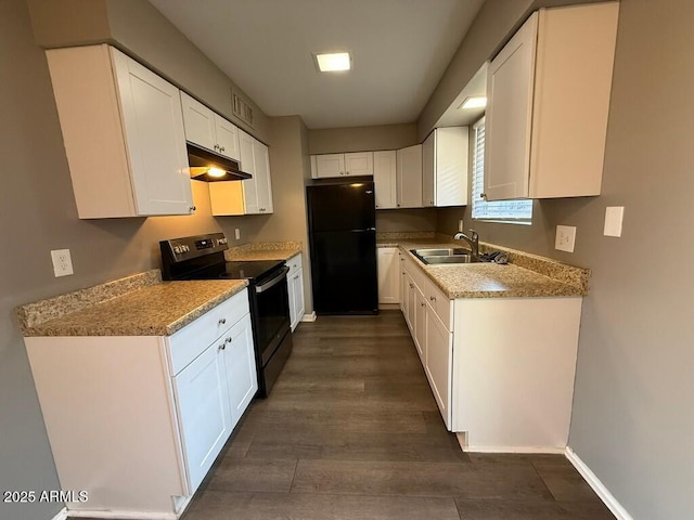 kitchen with under cabinet range hood, a sink, white cabinets, stainless steel electric range, and freestanding refrigerator