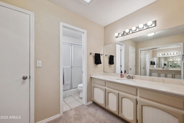 bathroom with tile patterned floors, vanity, toilet, and a stall shower