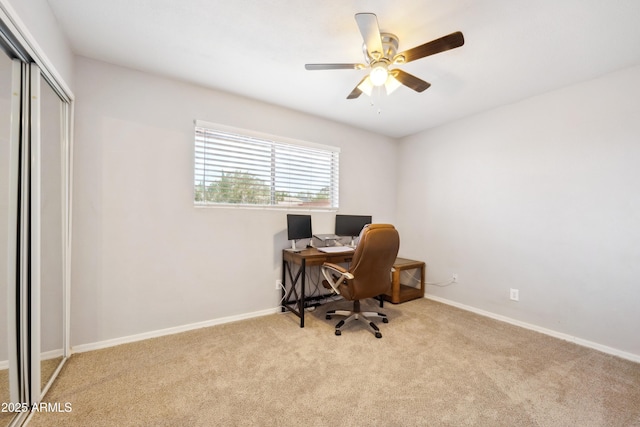 carpeted home office with baseboards and ceiling fan