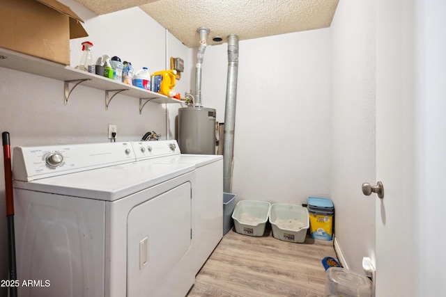 laundry area featuring light wood-style flooring, a textured ceiling, washer and dryer, laundry area, and water heater