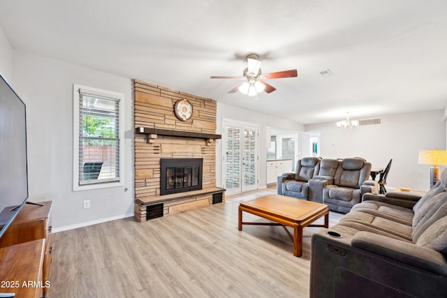 living area featuring light wood-type flooring, visible vents, and ceiling fan with notable chandelier