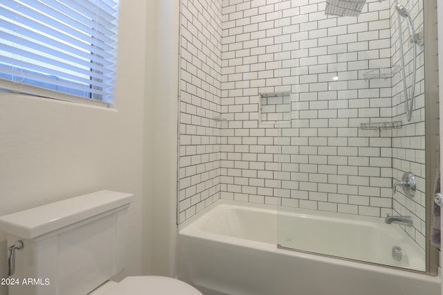 bathroom featuring tiled shower / bath and toilet