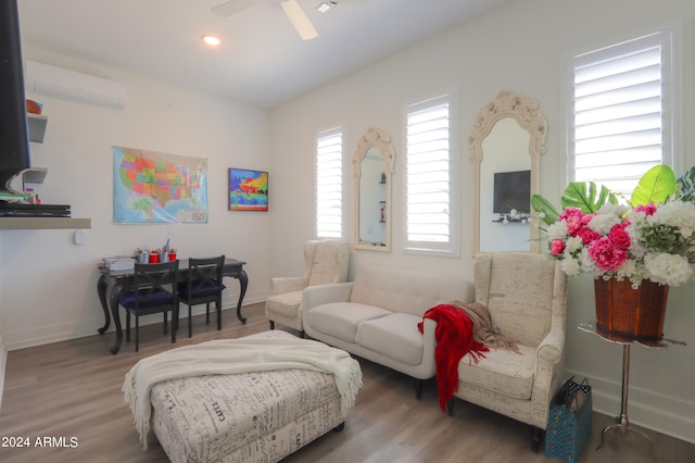 living room with a wall mounted AC, wood-type flooring, and ceiling fan