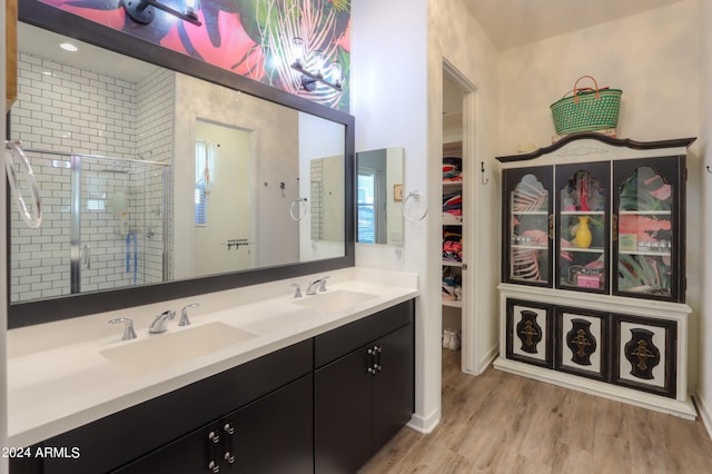 bathroom with vanity, a shower with shower door, and hardwood / wood-style floors