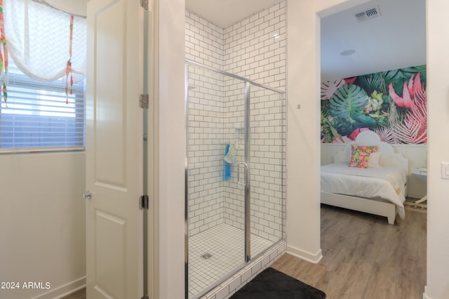 bathroom with wood-type flooring and a shower with shower door