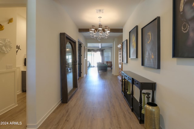 corridor featuring a notable chandelier and hardwood / wood-style flooring