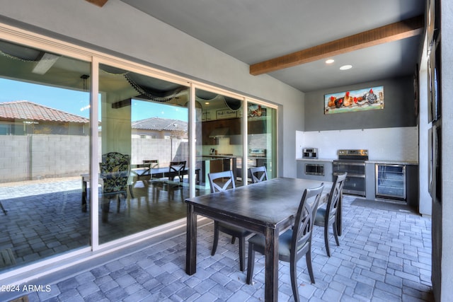 dining room featuring beamed ceiling and beverage cooler