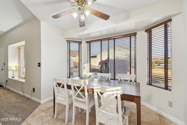 tiled dining area featuring ceiling fan and a textured ceiling