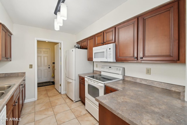 kitchen featuring white appliances, sink, hanging light fixtures, and light tile patterned floors