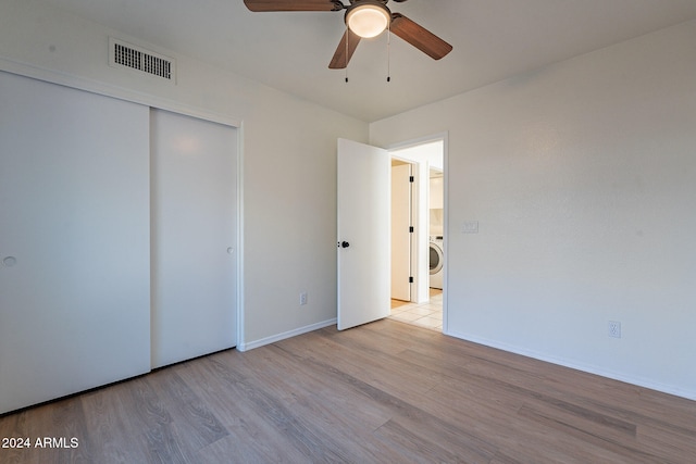 unfurnished bedroom with washer / clothes dryer, ceiling fan, and light hardwood / wood-style floors