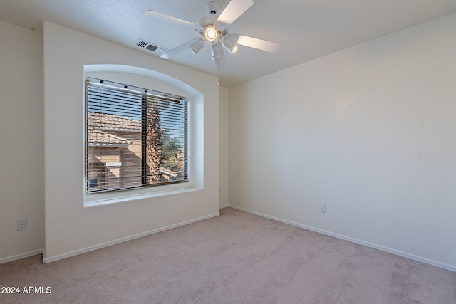 empty room with ceiling fan and light carpet