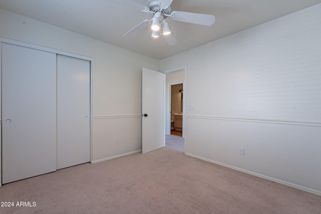 unfurnished bedroom with a closet, light colored carpet, and ceiling fan