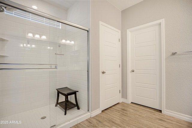 3523 W Rhapsody Dr, Sierra Vista, AZ 85650 - bathroom with baseboards, a stall shower, and wood finished floors