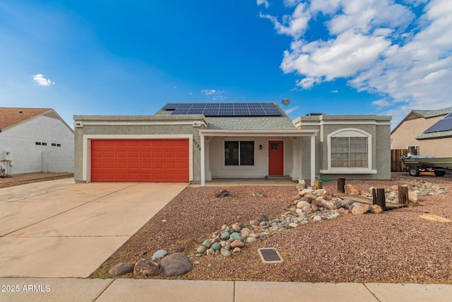 single story home featuring covered porch, an attached garage, concrete driveway, roof mounted solar panels, and stucco siding