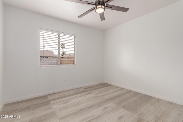spare room with wood finished floors, ceiling fan, and baseboards