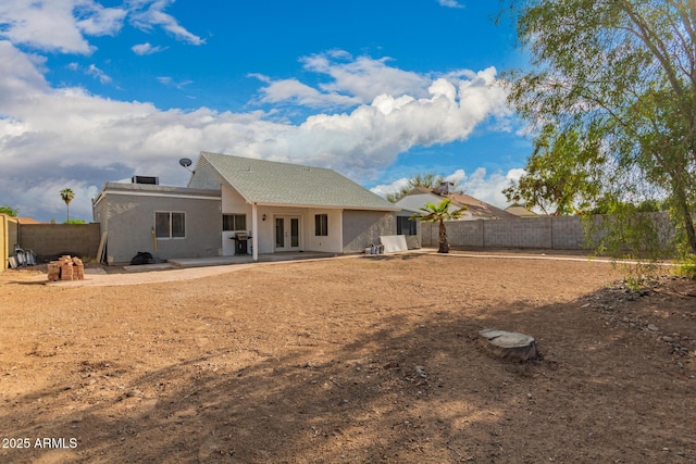 rear view of property with french doors, a fenced backyard, and a patio area