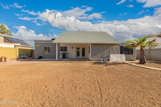 rear view of house featuring french doors, fence, stucco siding, and a patio