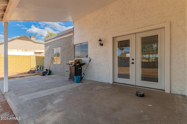 view of patio featuring french doors, area for grilling, and fence