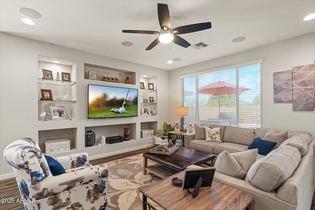living area featuring wood finished floors, ceiling fan, built in features, recessed lighting, and baseboards