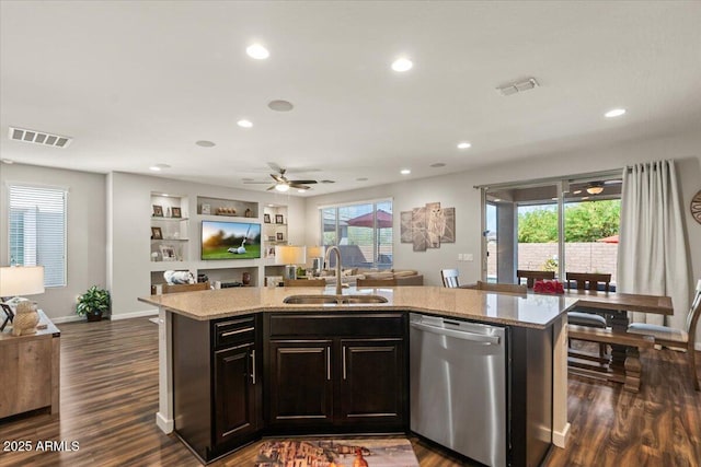 kitchen featuring dishwasher, a sink, open floor plan, an island with sink, and recessed lighting