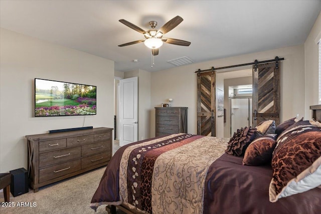 bedroom featuring a barn door, light colored carpet, and ceiling fan