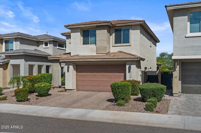 prairie-style home featuring a garage, decorative driveway, stucco siding, and a tile roof