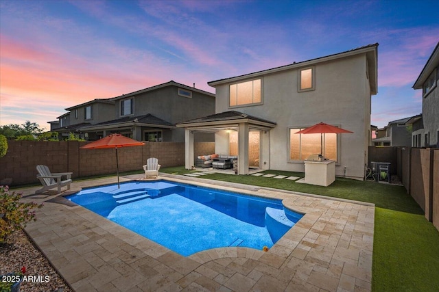 pool at dusk with a patio area, an outdoor hangout area, a fenced backyard, and a gazebo
