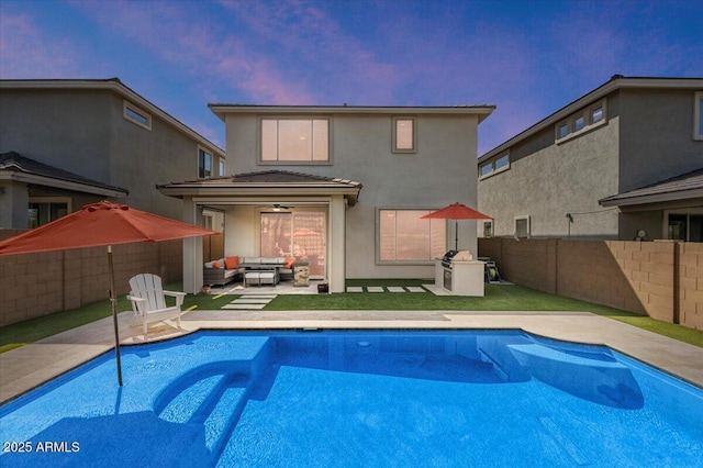 back of house at dusk featuring an outdoor living space, stucco siding, a fenced backyard, and ceiling fan
