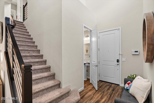 stairs featuring wood finished floors and baseboards