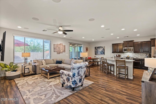 living area with dark wood-type flooring, healthy amount of natural light, a ceiling fan, and recessed lighting