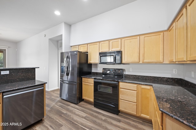 kitchen featuring dark stone countertops, light brown cabinets, dark hardwood / wood-style flooring, and black appliances