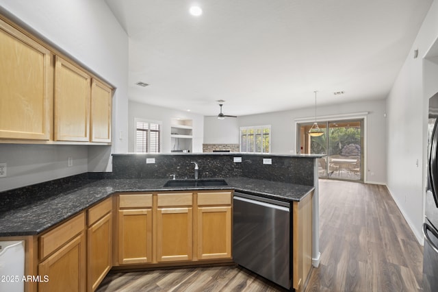 kitchen with dishwasher, sink, dark stone countertops, and kitchen peninsula