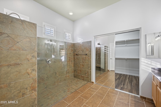 bathroom with tiled shower and vanity