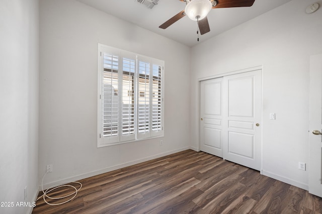 unfurnished bedroom with dark wood-type flooring, ceiling fan, and a closet