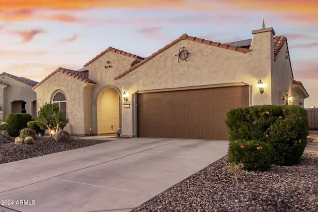 mediterranean / spanish home featuring a garage