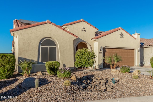 mediterranean / spanish-style home with a garage