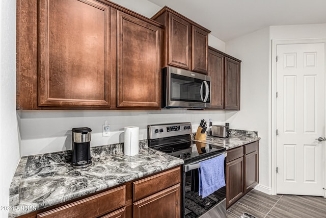 kitchen with dark stone countertops and stainless steel appliances