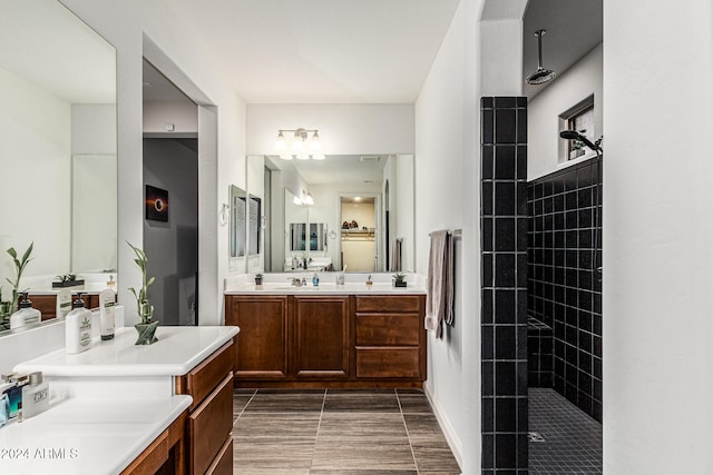 bathroom with tiled shower and vanity